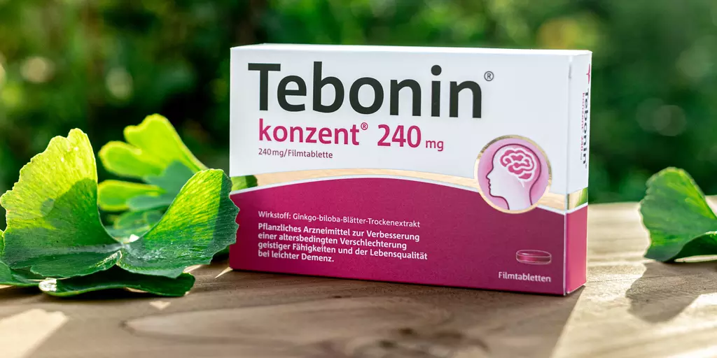 Tebonin® konzent® Packung steht auf einem Tisch und Ginkgo-Blätter liegen daneben
