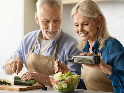 Älteres Paar bereitet gemeinsam einen Salat zu