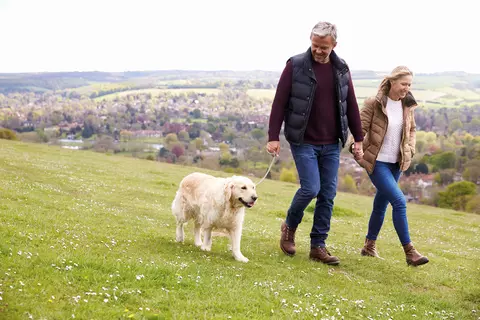 Paar mit Hund auf einem Spaziergang